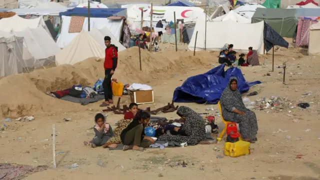 Palestinians who migrated from the Burayj Refugee Camp to Deir al-Balah are seen around tents in an empty area of Deir al-Balah, Gaza 