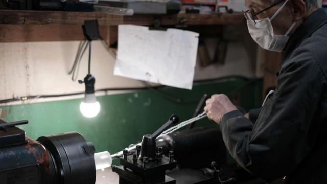 Trabalhador com máscara em uma fábrica japonesa 