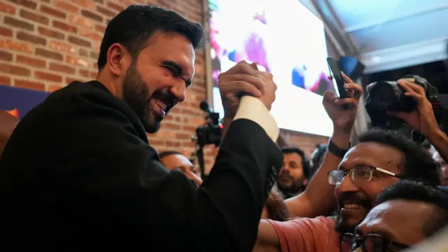 Foto de Zohran Mamdani cumprimentando seus apoiadores. 