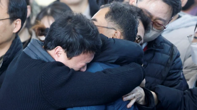 Anggota keluarga korban kecelakaan Jeju Air dalam duka di Bandara Internasional Muan, Korea Selatan, pada 30 Desember 2024.