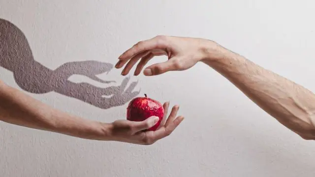 দুটি হাতের ছবি। একটি হাতে আপেল ধরা। আরেকটি ওই আপেল নেয়ার চেষ্টা করছে।