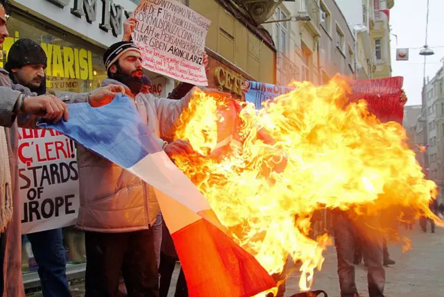 2006 yılında Danimarka Danimarka'da Peygamber Muhammed'i gösteren bazı karikatürlerin yayımlanmasını protesto etmek için İstanbul'da Danimarka bayrağı yakan göstericiler. 