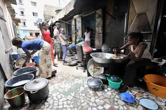 Des femmes préparent du riz et du poisson dans un restaurant de rue à Dakar,
