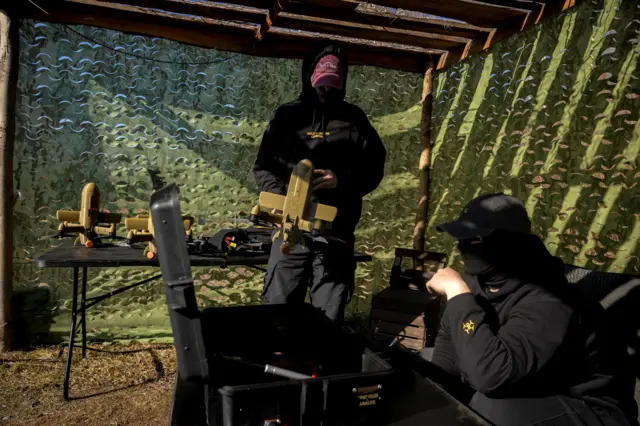 Двоє військових тримають в руках дрони перехоплювачі