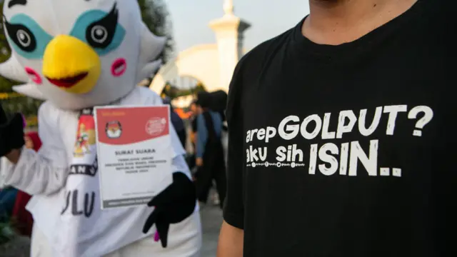Maskot pemilu membawa poster saat sosialisasi pemilu di kawasan Nol Kilometer Yogyakarta, Jumat (22/12/2023).