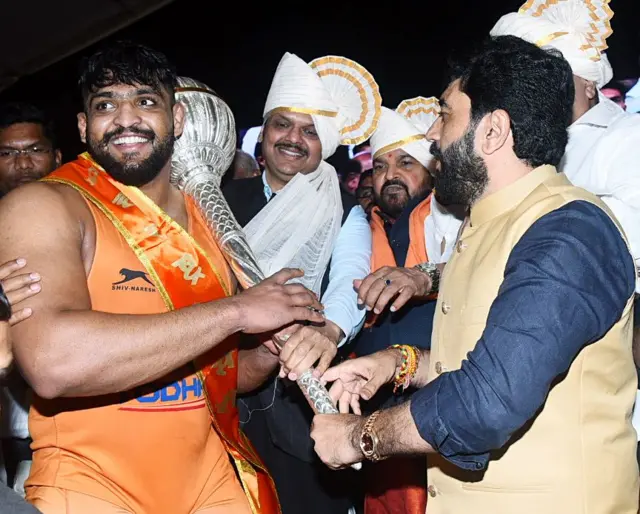 2023 मध्ये कुस्तीपटू शिवराज राक्षेने महाराष्ट्र केसरी स्पर्धा जिंकल्यानंतर त्याचा सत्कार करताना तत्कालीन उपमुख्यमंत्री देवेंद्र फडणवीस आणि इतर.