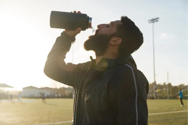 पानी पीता हुआ एक पुरुष खिलाड़ी 