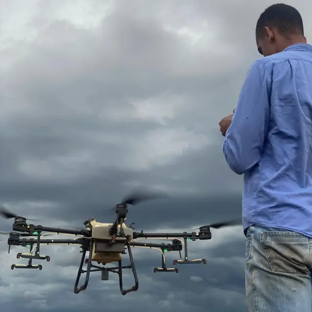 Gustavo de costas pilotando um drone