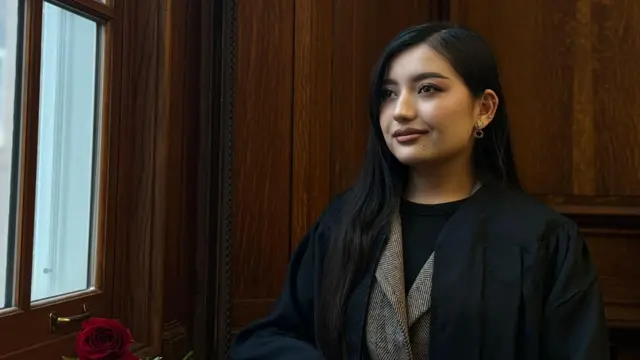 فوزیه محمدی پس از فراغت از دانشگاه در امریکا در مقابل یک پنجره ایستاده و به بیرون نگاه می‌کند. 