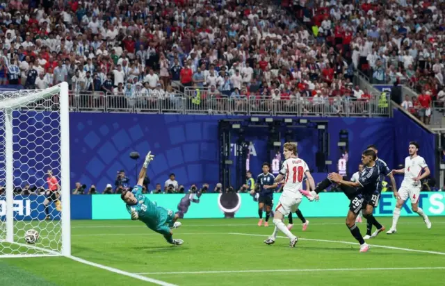 イングランドの選手が蹴りこんだボールがアルゼンチンのゴールに入ろうとしている。緑色のユニフォームのゴールキーパーが右に飛んでいるが、届かない。