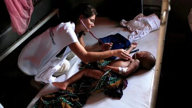 KOngo'da bir hasta çocuğu muayene eden kadın doktor