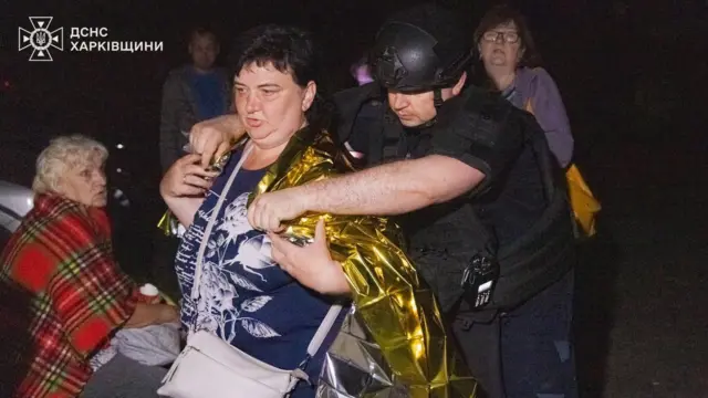 Працівники ДСНС заспокоюють місцевих жителів після російського удару по будинках
