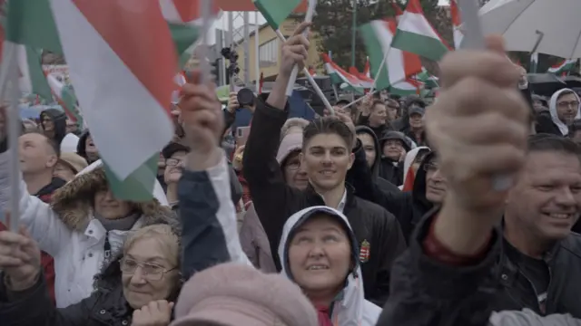 Люди в толпе с венгерскими флагами