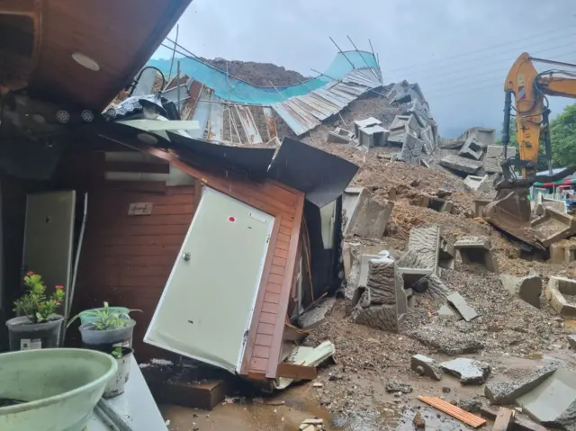 경기북부 지역에 호우 특보가 내려진 18일 경기 양주시 백석읍 기산리에서 산사태로 옹벽이 무너지며 주택을 덮쳐 소방대원이 복구작업을 하고 있다