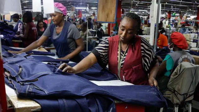 Deux femmes tenant un matériau textile pour le mesurer