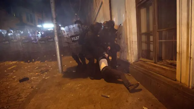 Несколько спецназовцев волокут протестующего в Тбилиси во время разгона акции 28 ноября 2024 года 
