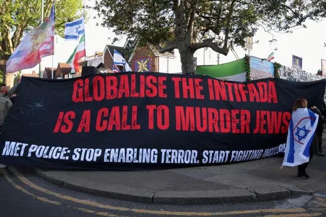 يحمل متظاهرون لافتة خلال احتجاج في لندن، بعد اعتقال رجل على خلفية حادث طعن في منطقة 