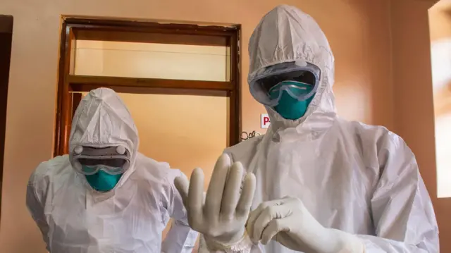 عاملان في القطاع الطبي يرتديان ملابس واقية.