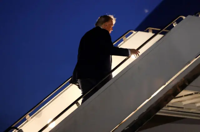 Trump subindo escadas de avião
