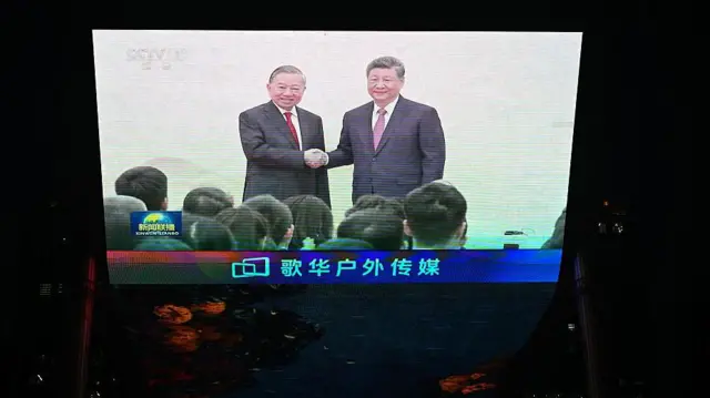 Màn hình tại một trung tâm thương mại chiếu cảnh Chủ tịch Trung Quốc Tập Cận Bình (phải) bắt tay với Tổng Bí thư, Chủ tịch nước Việt Nam Tô Lâm hôm 15/4/2026