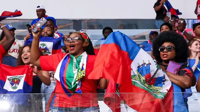 Torcedores do Haiti agitam bandeiras na partida de aquecimento da Copa do Mundo contra o Perú