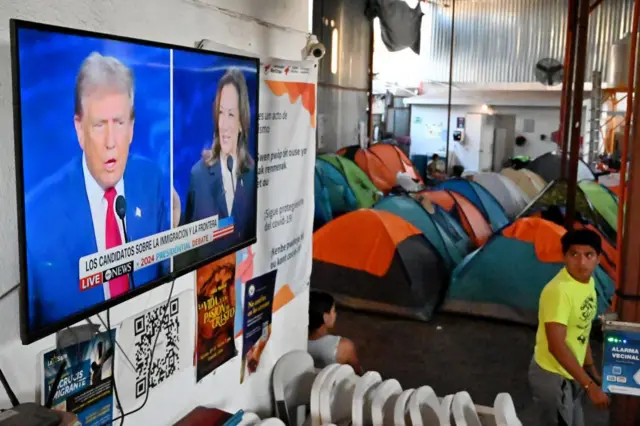 Debate passando na TV, com pessoas e barracascassino da blazeacampamento dentrocassino da blazeabrigo