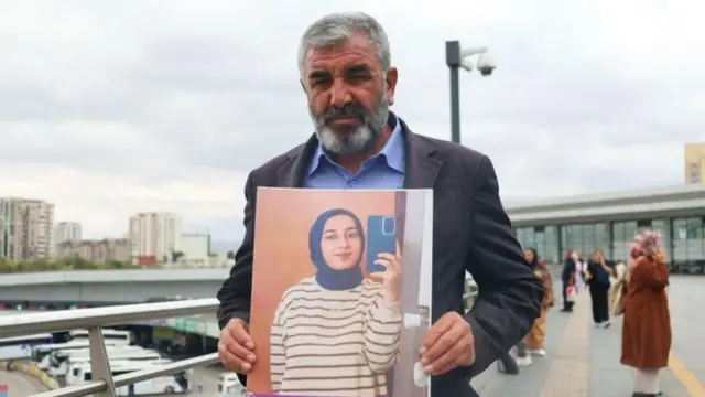 Nizamettin Kabaiş, 2024'te hayatını kaybeden kızı Rojin Kabaiş'in fotoğrafınnı gösteriyor