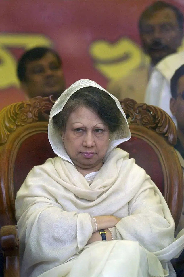 ২০০৮ সালের ২৭শে ডিসেম্বর ঢাকায় একটি নির্বাচনী প্রচারণা সমাবেশে নিরাপত্তার স্বার্থে স্থাপন করা বুলেটপ্রুফ ঢালের দিকে তাকিয়ে আছেন খালেদা জিয়া। এর আগে,সাবেক এই প্রধানমন্ত্রী ও তার বড় ছেলের বিরুদ্ধে এতিমখানার অর্থ আত্মসাতের অভিযোগ দায়ের করে বাংলাদেশ দুর্নীতি দমন কমিশন।