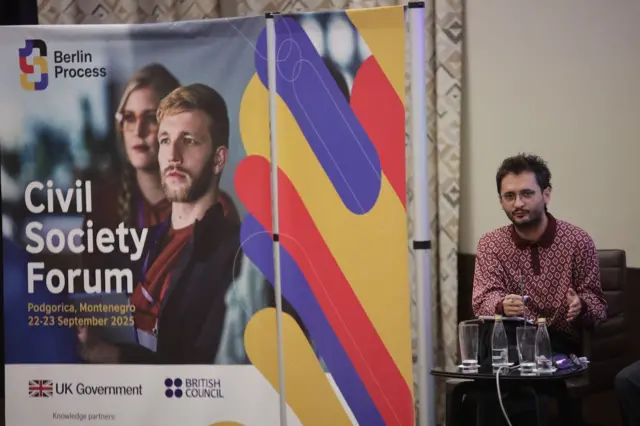 Govornik stoji pored panela foruma civilnog društva