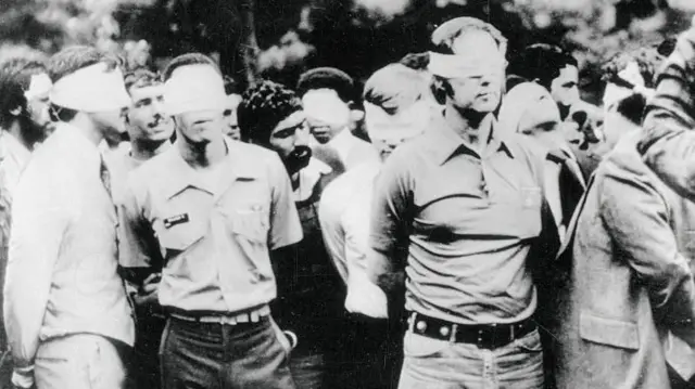 पहिल्या दिवशी मीडिया आणि जनतेसमोर ओलीस ठेवलेल्या अमेरिकन नागरिकांचे परेड करतानाचचा फोटो