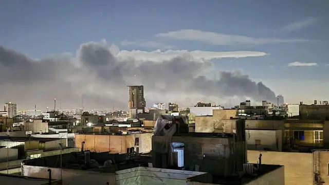 Coluna de fumaça subindo de um bairro iraniano
