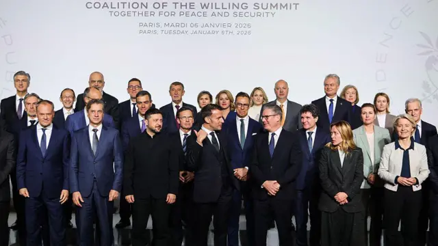 Önde Fransa Cumhurbaşkanı Emmanuel Macron (ortada) ve İngiltere Başbakanı Keir Starmer (sağdan 3. sırada), 6 Ocak 2026'da Paris'teki Elysee Sarayı'nda, Ukrayna için güvenlik garantileri konulu zirvede; Yanlarında Polonya Başbakanı Donald Tusk, Slovenya Başbakanı Robert Golob, Ukrayna Devler Başkanı Volodymyr Zelensky, İtalya Başbakanı Giorgia Meloni ve Avrupa Komisyonu Başkanı Ursula Von der Leyen ile birlikte aile fotoğrafı çektirirken konuşuyorlar.