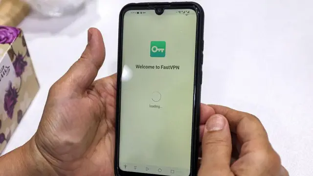 یک فرد پس از فعال‌کردن سرویس شبکه خصوصی مجازی (VPN) برای دسترسی به اینترنت، گوشی خود را در تهران در تاریخ دوشنبه ۲۰ شهریور ۱۴۰۲ در دست دارد. مقامات ایرانی از زمان آغاز اعتراضات گسترده پس از مرگ مهسا امینی، کرد ۲۲ ساله ایرانی، در بازداشت پلیس در شهریور ۱۴۰۱، شبکه‌های اجتماعی محبوب از جمله اینستاگرام و واتس‌اپ را مسدود کرده‌اند. این محدودیت‌ها در حالی اعمال می‌شوند که میلیون‌ها ایرانی برای تأمین زندگی روزمره خود تلاش می‌کنند و با بحرانی اقتصادی مواجه‌اند که با تحریم‌های شدید غربی، تورم افسارگسیخته و سقوط شدید ارزش پول محلی همراه است.