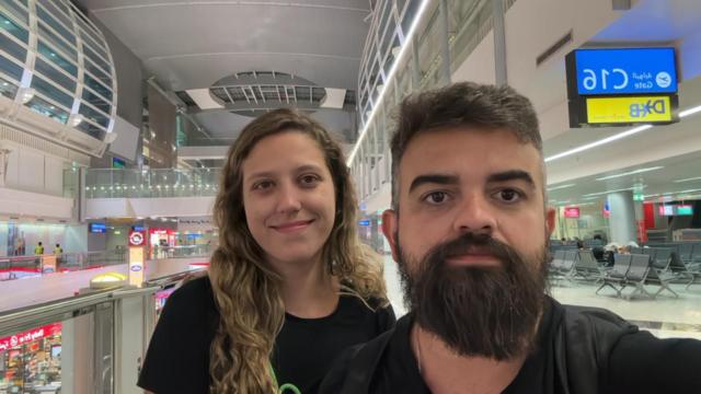 Casal posando para foto dentro de aeroporto