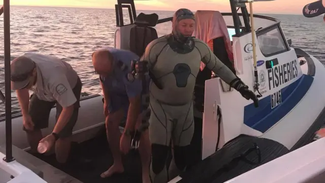 John Craig in his diving costume on a rescue boat
