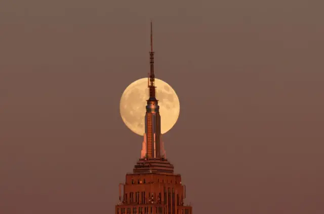 Superlua surgindo atrás do Empire State Building, na cidade de Nova York, ao anoitecer de 16 de outubro de 2024.