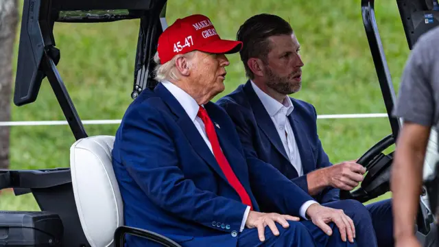 Donald Trump y su hijo Eric Trump en un carrito de golf en el Trump National Doral Miami, el 3 de abril de 2025 en Doral, Florida. 