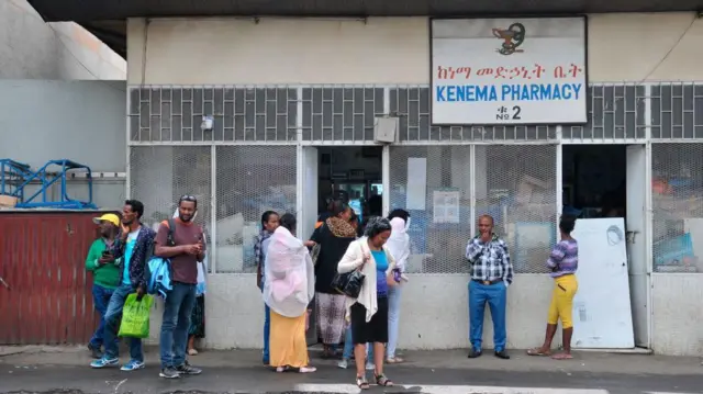 የከነማ መድሃኒት ቤት ደጃፍ የተሰለፉ ሰዎች