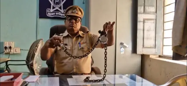 उपनिरीक्षक बी.टी.सहाणे शहनाज यांच्या पायातील लोखंडी साखळदंड दाखवताना.