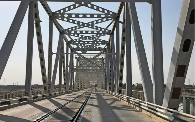 Temirdan yasalgan, kul rang, temir yo'l va avto yo'l o'tgan ko'prik, kun yorug'