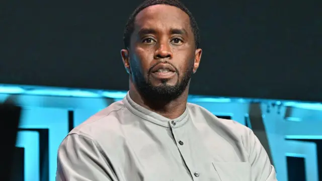 Fotosporting palpite hojeSean Combs, um homemsporting palpite hojepele escura, vestindo uma camisa cinza abotoada até o pescoço. 