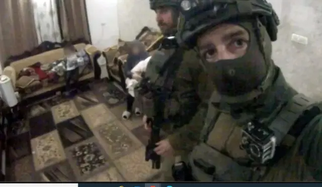 A screenshot from one of Yohai Vazana’s videos shows members of his battalion posing in front of a Palestinian woman with a child