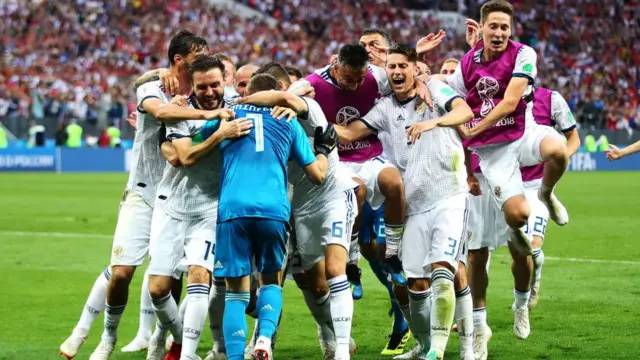 Los jugadores rusos abrazar a su portero tras la clasificación a cuartos de final.