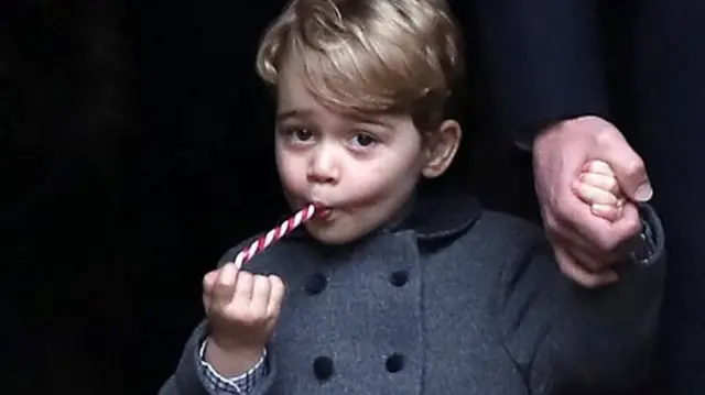 25 December 2016: George is given a candy cane after leaving the morning Christmas Day service at St Mark's Church, Englefield, near his maternal grandparents' home at Bucklebury, Berkshire