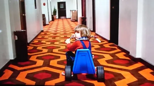 Пятилетний Дэнни, гоняющий на своем трехколесном велисипеде по покрытым бесконечным коридорам отеля "Оверлук", покрытым коврами со сводящим с ума монотонным орнаментом, - один из самых зловещих образов "Сияния"