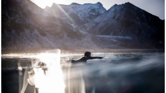 Сёрфер плывет на доске