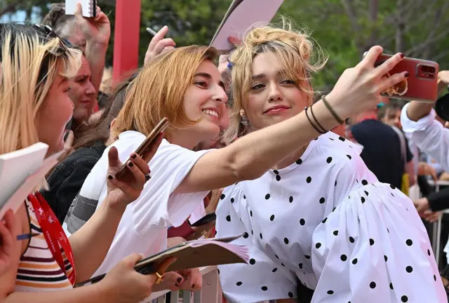 भेनिस चलचित्र महोत्सवमा पहिलोपल्ट प्रदर्शन भएको लिभिङ चलचित्रका नायिका एमी लु वुड आफ्ना समर्थकसँग तस्बिर खिचाउँदै