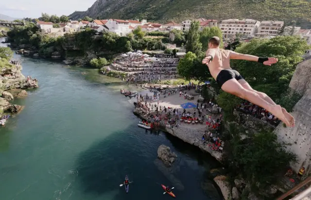 Nin ka soo duulayo buundo ku taallo webiga Neretva oo uu ka dhacayay tartanka dabbaasha.