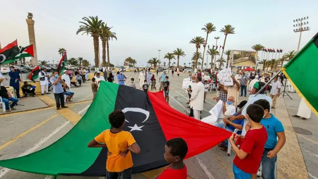 Abantu bakoranye kandi bazungagiza amabendera mu kibanza c'abamaratiri, ku murwa mukuru wa Libya, Tripoli