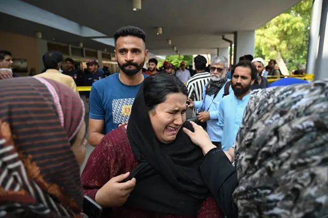 Jaweria (C), who said she lost her child in the fire, reacts following a blaze at the Mother and Child Health (MCH) ward of the Pakistan Institute of Medical Sciences (PIMS) Hospital in Islamabad on August 26, 2026. A fire in a maternity ward at a public hospital in the Pakistani capital Islamabad on August 26 morning killed 14 children, a local authority said.